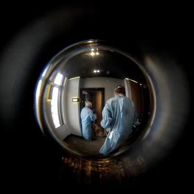 Two medics in hazmat suits distorted through a fisheye lens