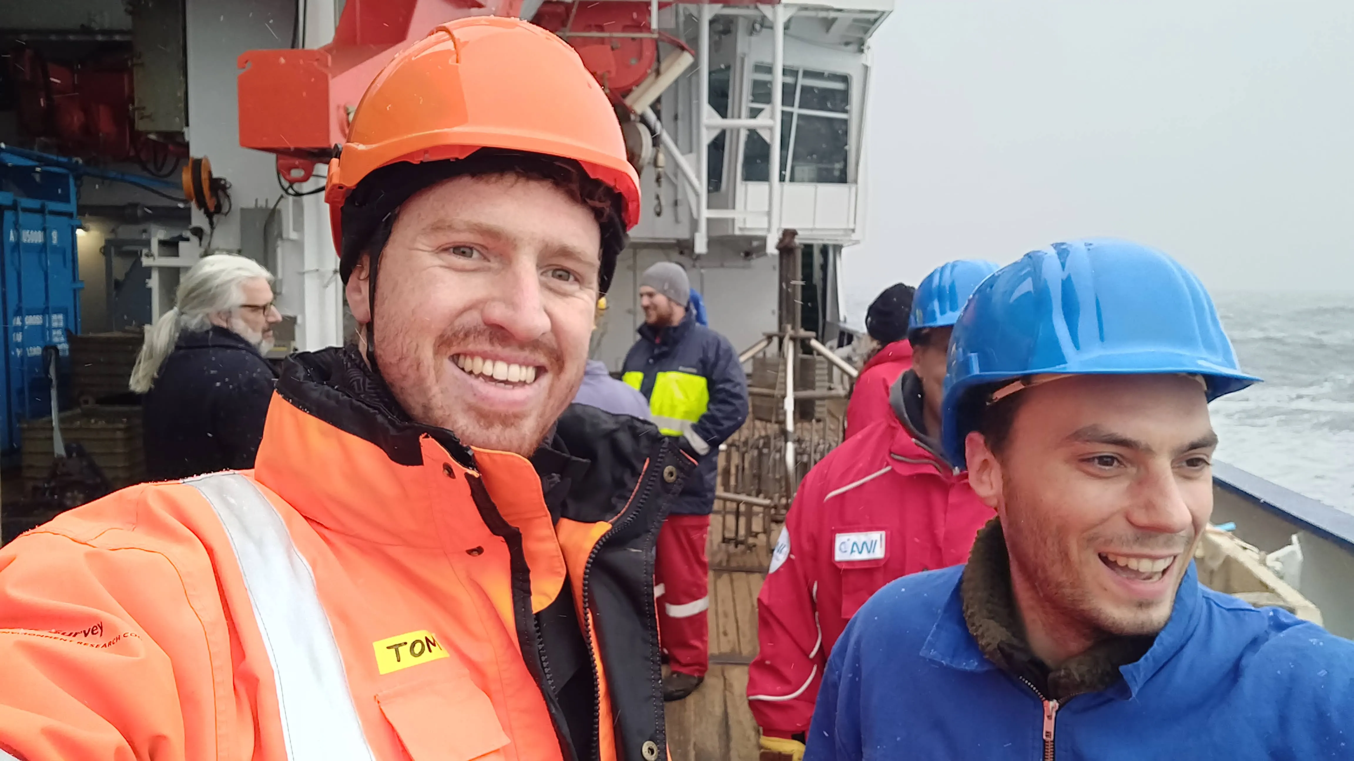 Photo of two men in working clothes on the deck on a ship